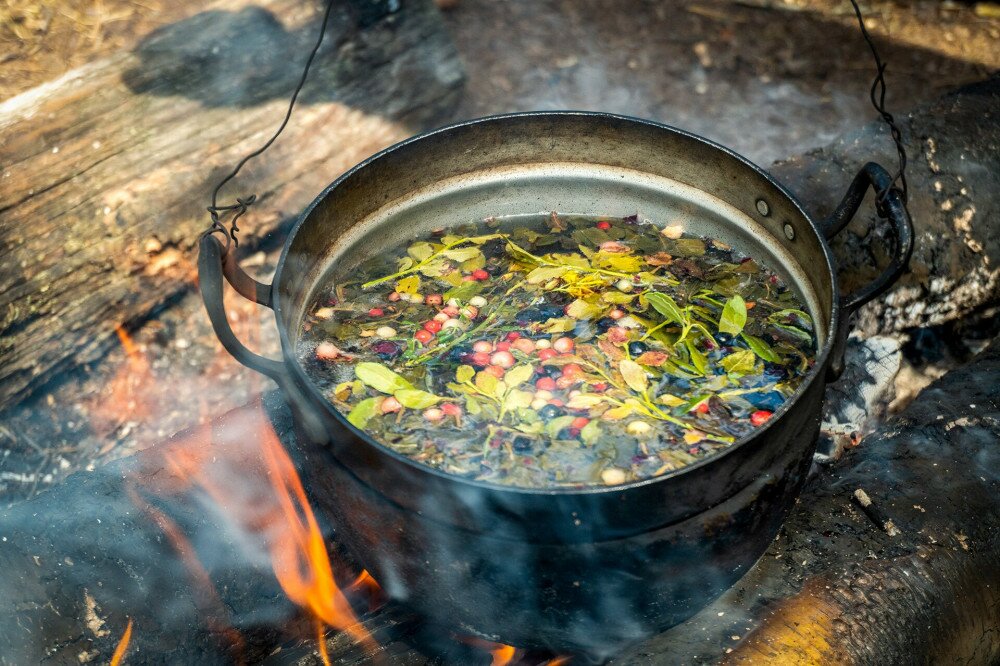 A pot with a herbal tea on campfire
