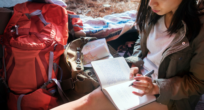 Lány naplót ír egy sátorban